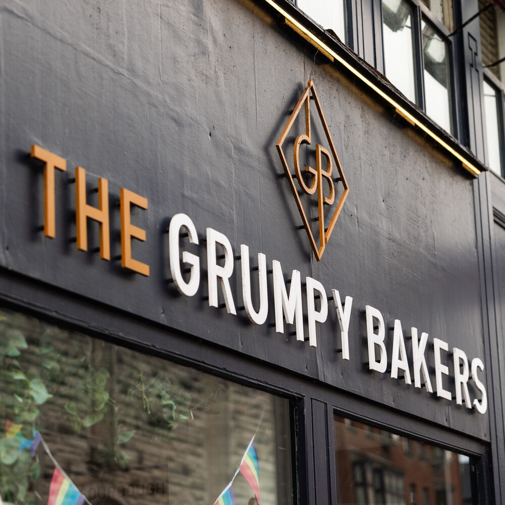 Close-up of the shop fascia and the copper-gold GB monogram.